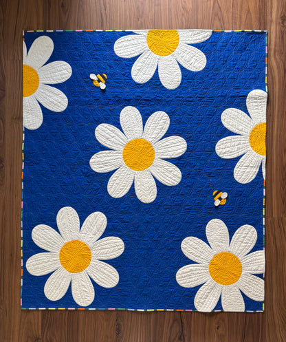 Quilt with daisy pattern on a wooden surface
